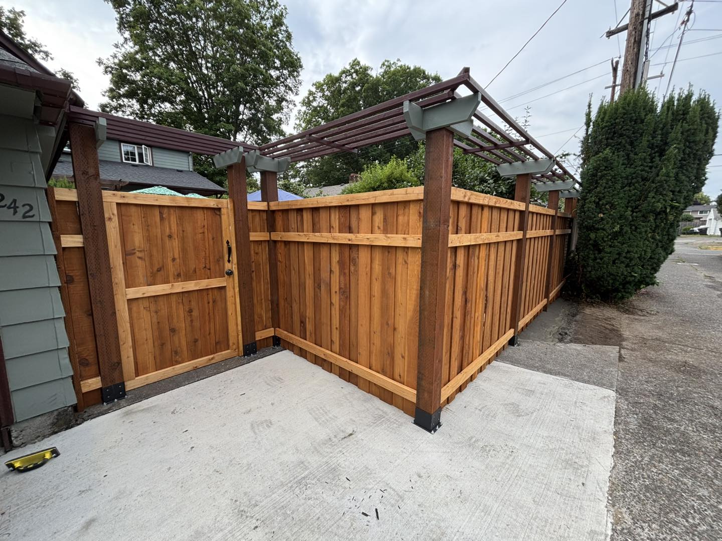 Privacy fence with decorative pergola-style top beams